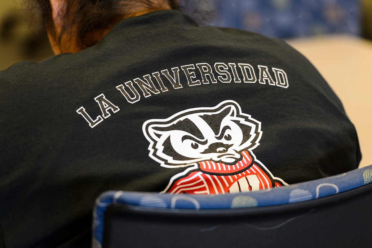 A person wearing La Universidad de Wisconsin t-shirt.