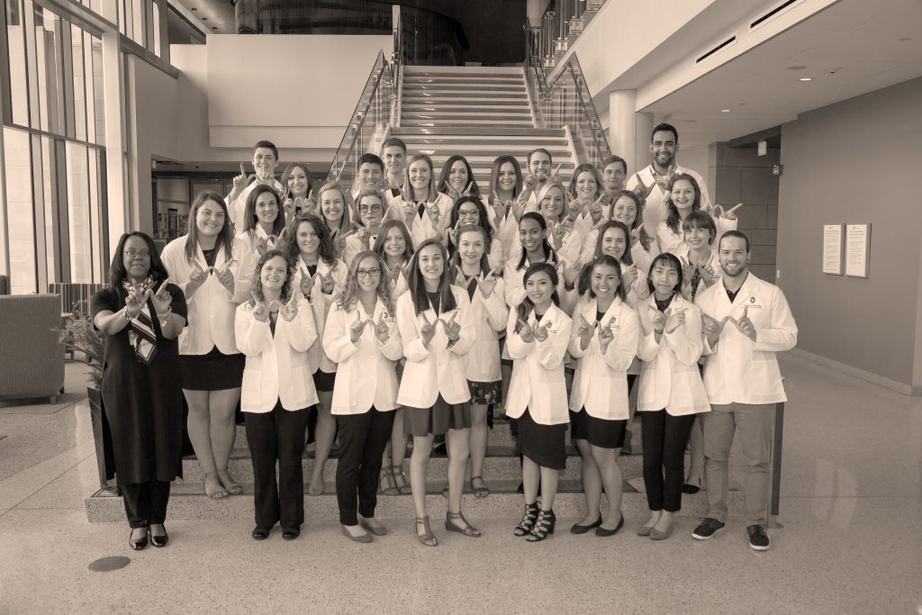 Members of the first cohort of the Accelerated BSN program show their Badger nurse pride as they celebrate the start of their nursing journeys with the white coat ceremony on May 17, 2018.