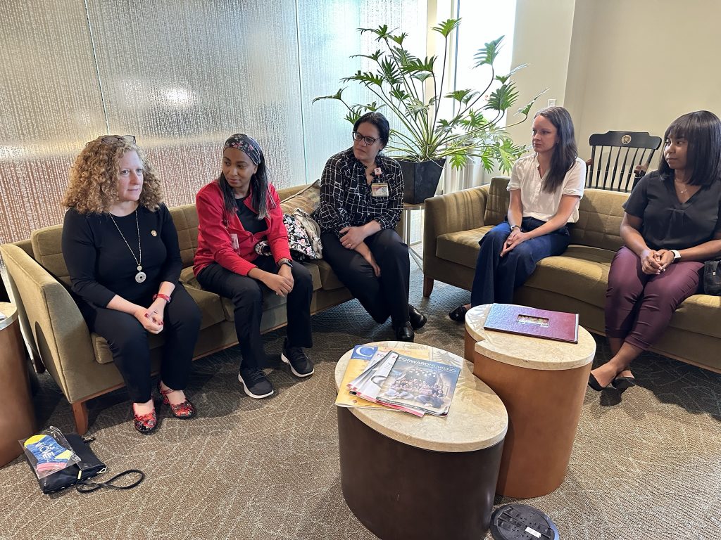 Chancellor Jennifer Mnookin and group of four women chat while sitting on two couches.