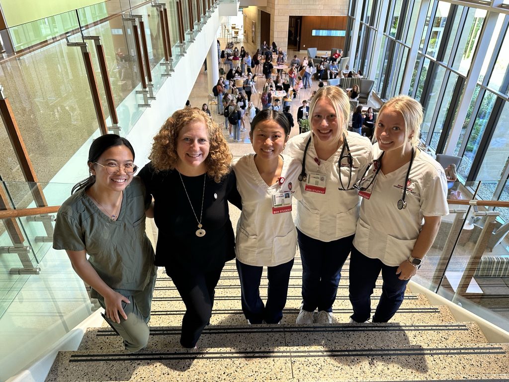 Chancellor Jennifer Mnookin poses on stairs with undergraduate nursing students Alexandra Goldenberg, Julie Jones, Nicole Bartels, and Holly Adams.