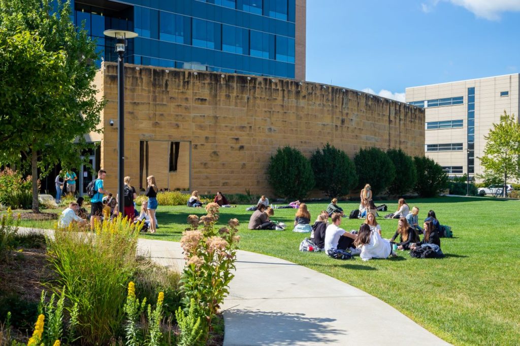 Students sit on the grass outside Cooper Hall.