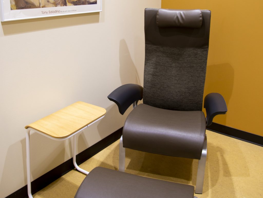 A meditation and self-care room in Cooper Hall with an easy chair and foot rest.