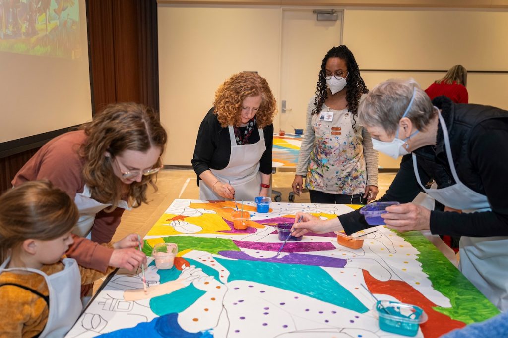 Chancellor Jennifer Mnookin joins the community mural painting alongside artist Tia Richardson.