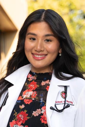 Sonam Dorjee sits in a flowered dress and white nursing coat.