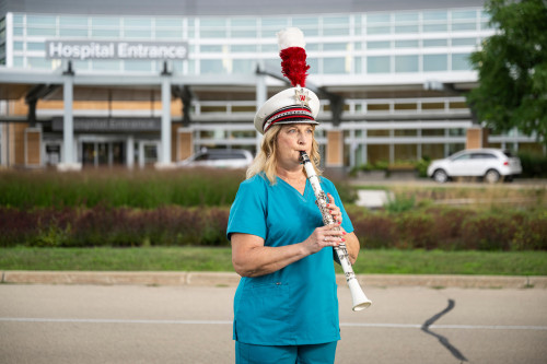 Tammy Coplien plays a clarinet in front of a hospital on the east side of Madison.