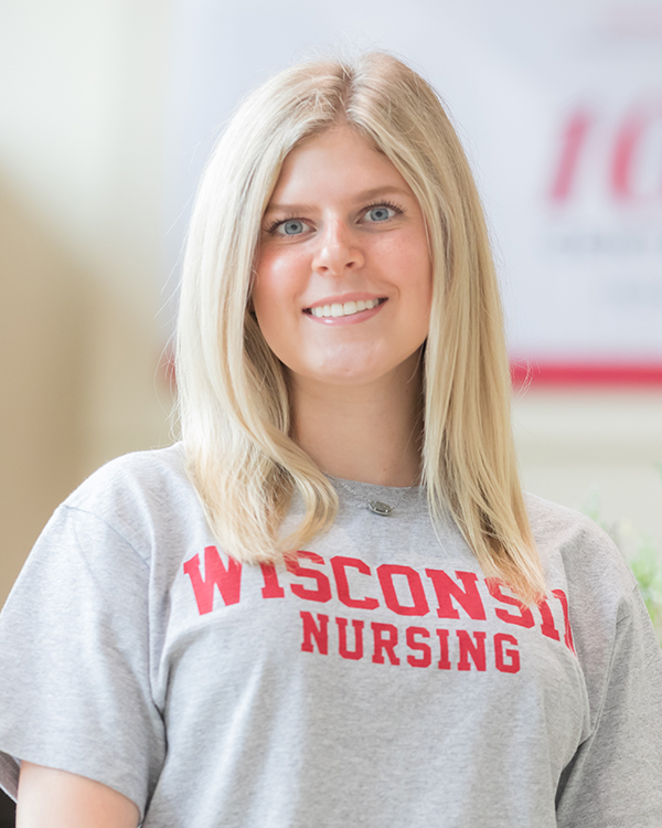 Headshot of Allie Young from the waist up, wearing a gray t-shirt that says "Wisconsin Nursing" in red text.