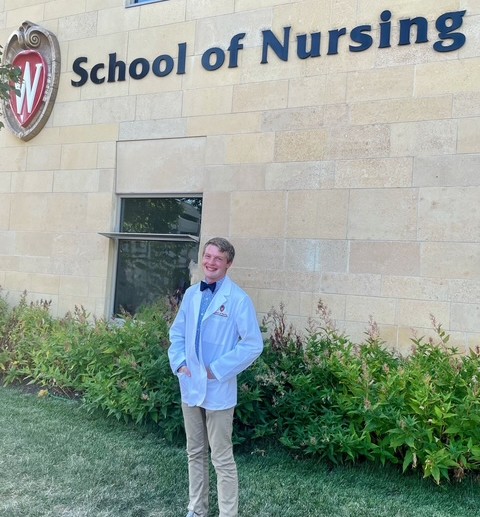 Green stands in front of Cooper Hall in his white coat.