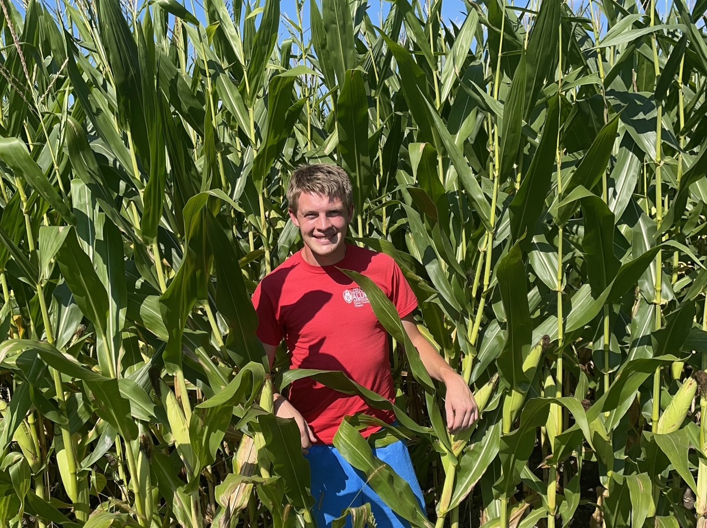 Joseph Green smiles while peering out between corn stalks on his grandparents' farm near Monroe, WI.