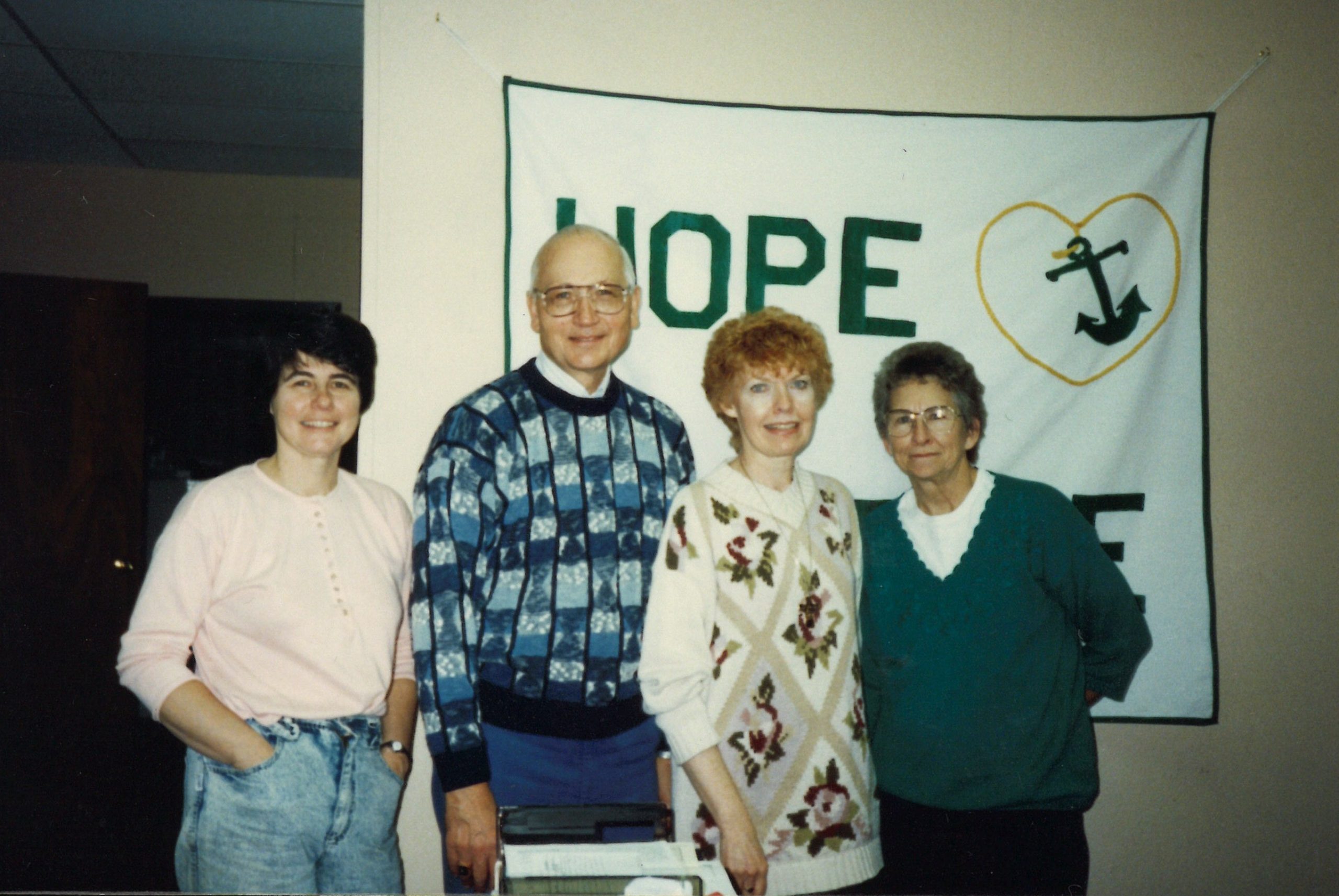 Barb Meyer and her crew in front of a “Hope Hospice” banner in the new office on Main Street, Rib Lake in 1994.