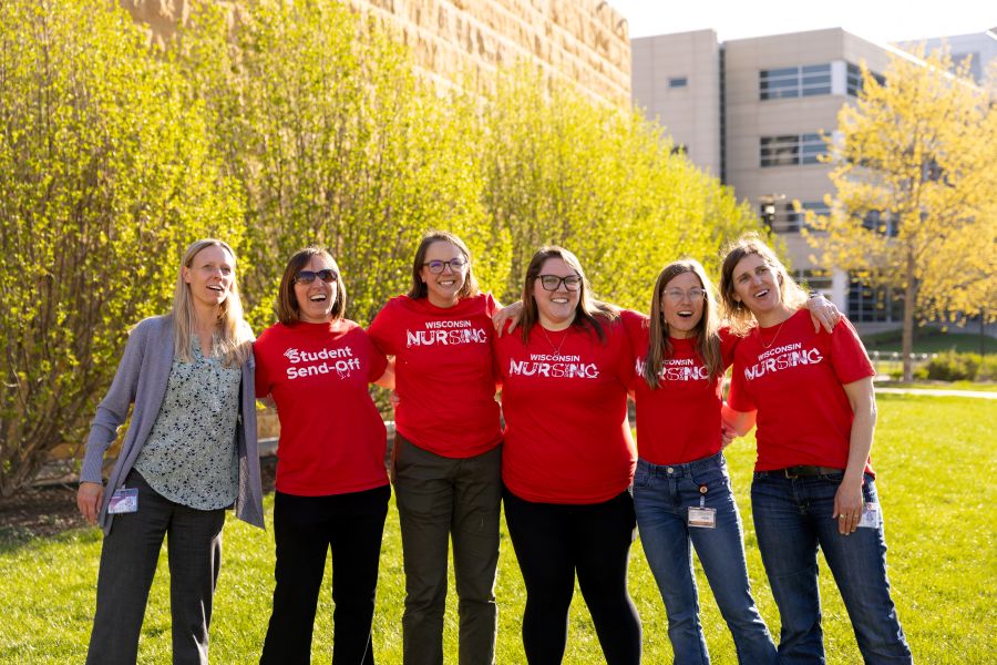 Dr. Roberts and colleagues link arms and sing at the end-of-year student sendoff celebration.