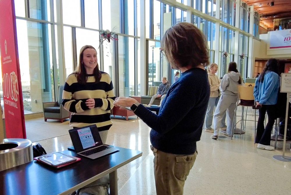 A Traditional BSN student speaks with a faculty member during a TBSN poster presentation in Cooper Hall.