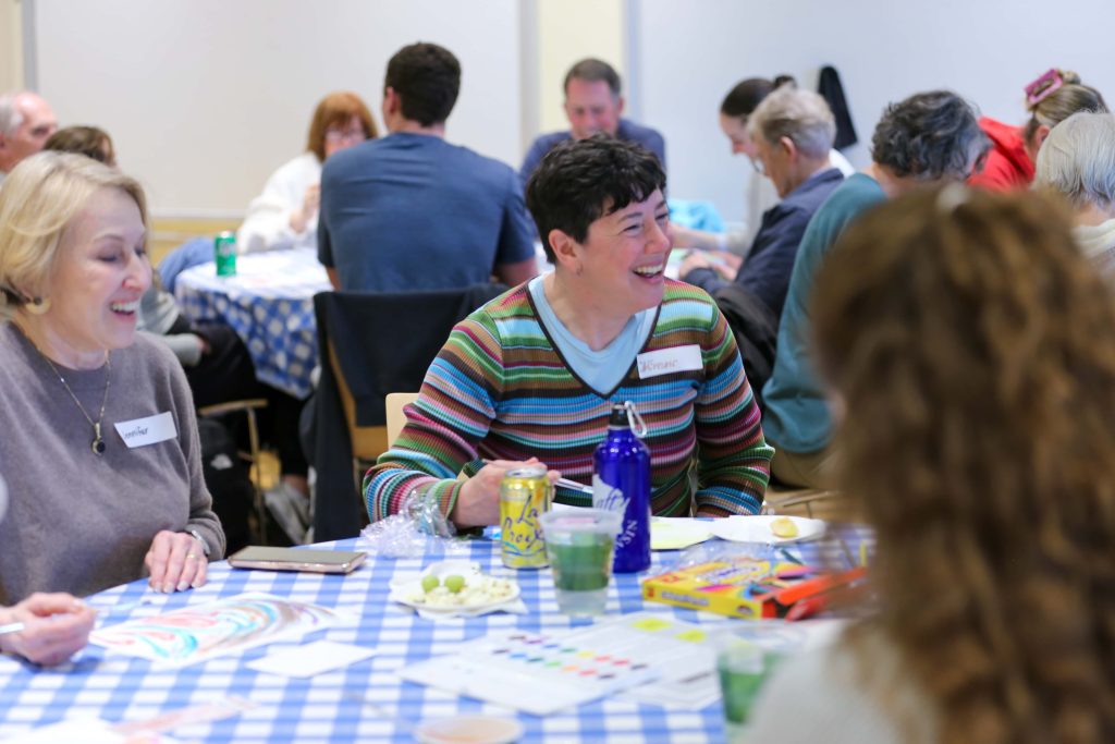 Farsetta laughs with students and older adults while eating lunch at the "Art of Aging" event.