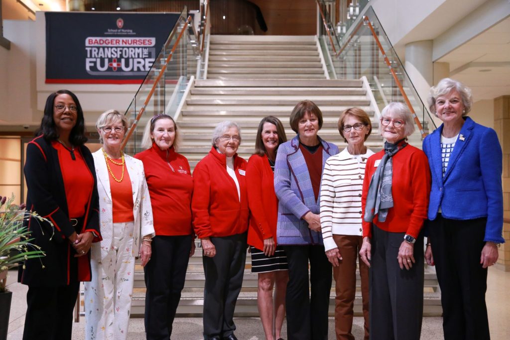 The UW-Madison Board of Visitors stands at the foot of the staircase in Cooper Hall.