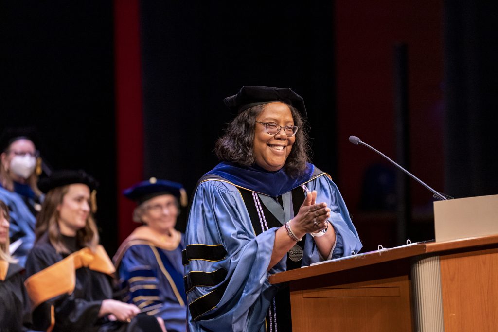 Linda D. Scott in cap and gown stands at the podium during the School of Nursing graduation ceremony at the Memorial Union.