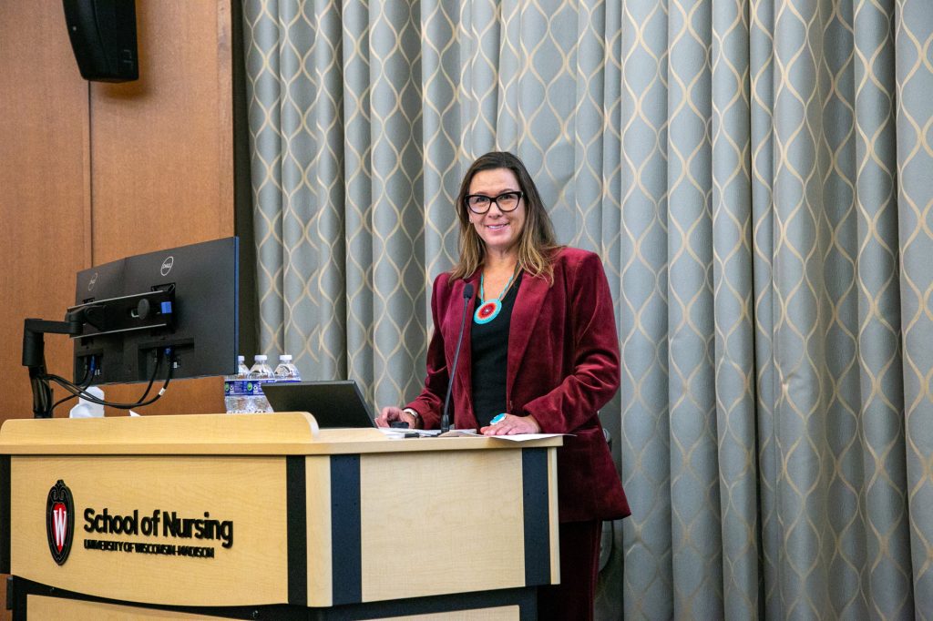 Dr. Amy DeLong, MD, (Ho-Chunk Nation) stands at the podium during her presentation.