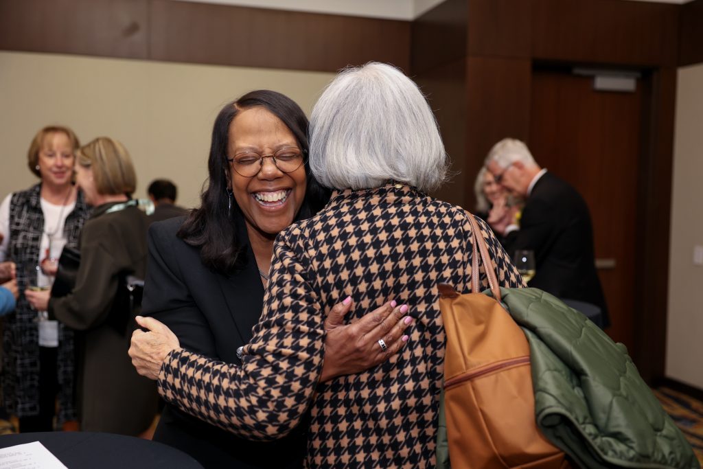 Dean Emerit Scott shares a warm hug with a colleague at the 2025 AAN conference.