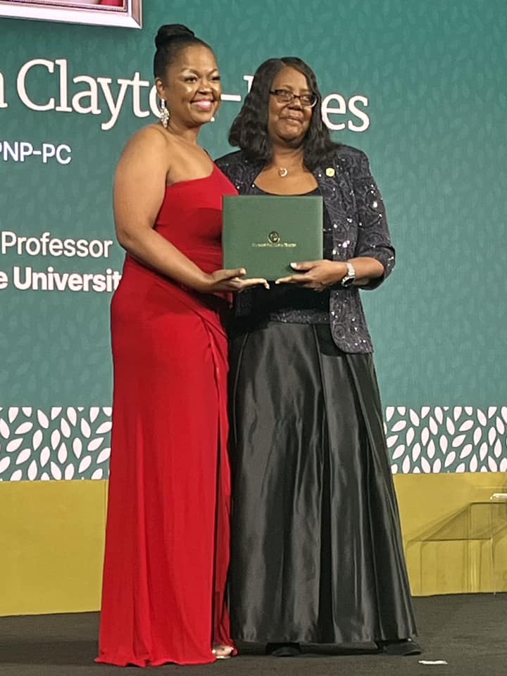 Dean Emerit Scott and Dora Clayton Jones, Associate Professor, Marquette University in formal gowns on the stage at the American Academy of Nursing.
