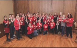 Natalee Berg, Linda Scott, and colleagues pose for a group photo wearing red.