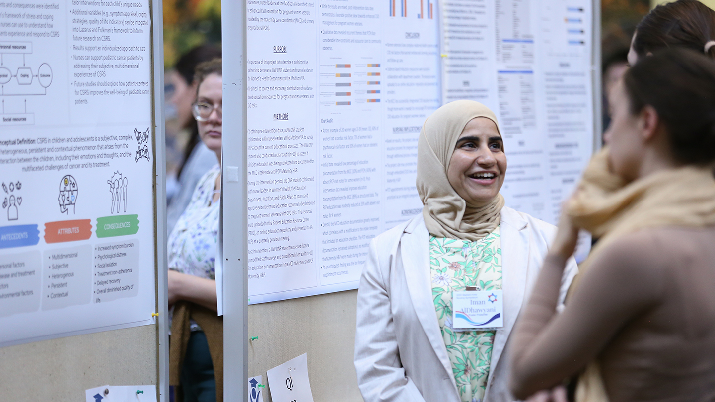 A presenter chats with a visitor at the Madison Area Nursing Symposium.