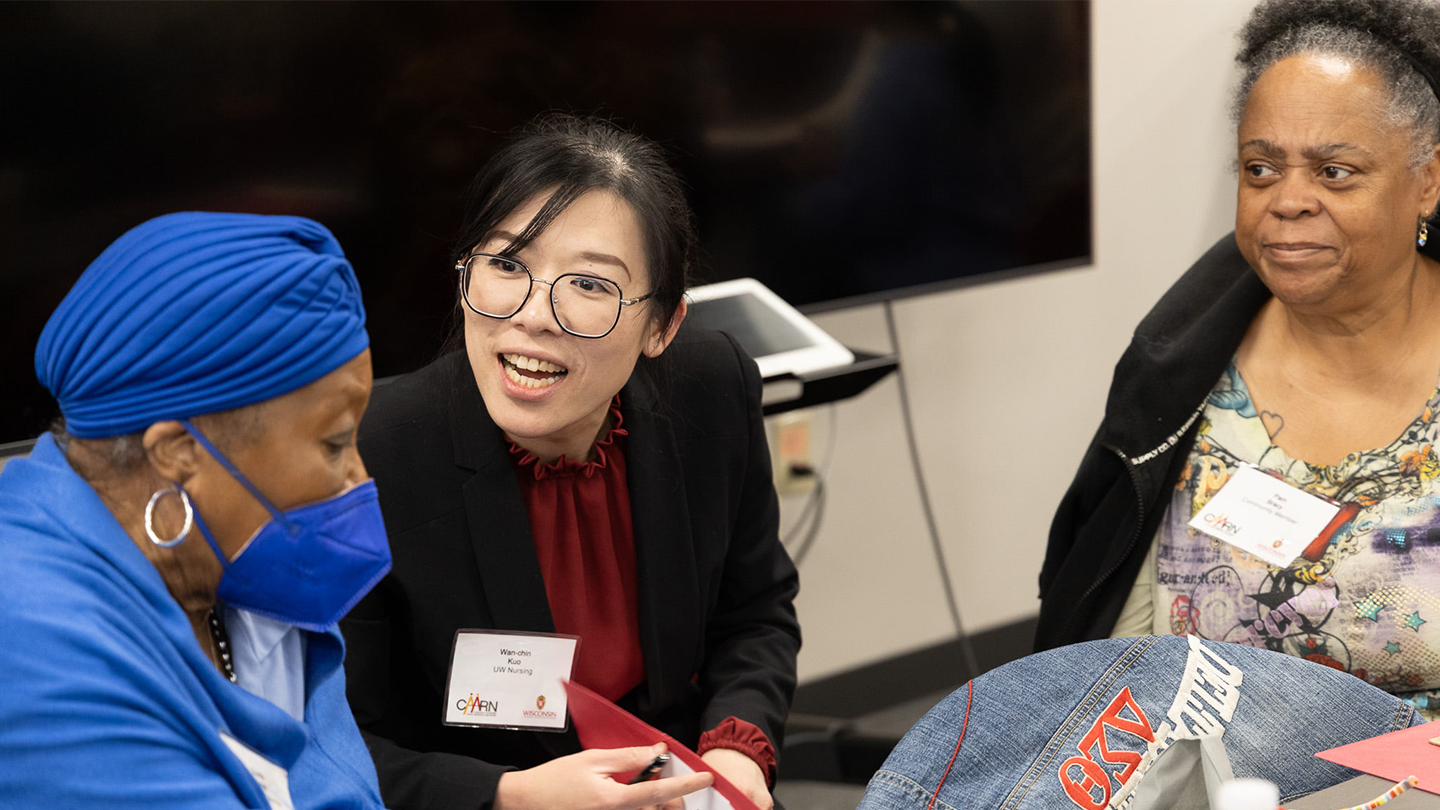 Dr. Wan-chin Kuo talks animatedly with participants in The Community-Academic Aging Research Network (CAARN) conference. Photo credit: Dynae Allice.