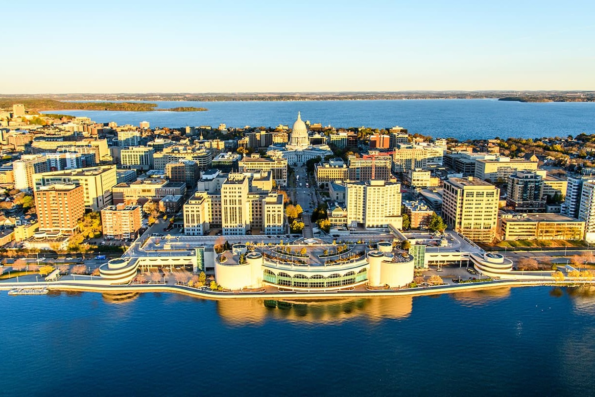 An aerial view of Madison's isthmus with the capitol at the center and lakes on either side.