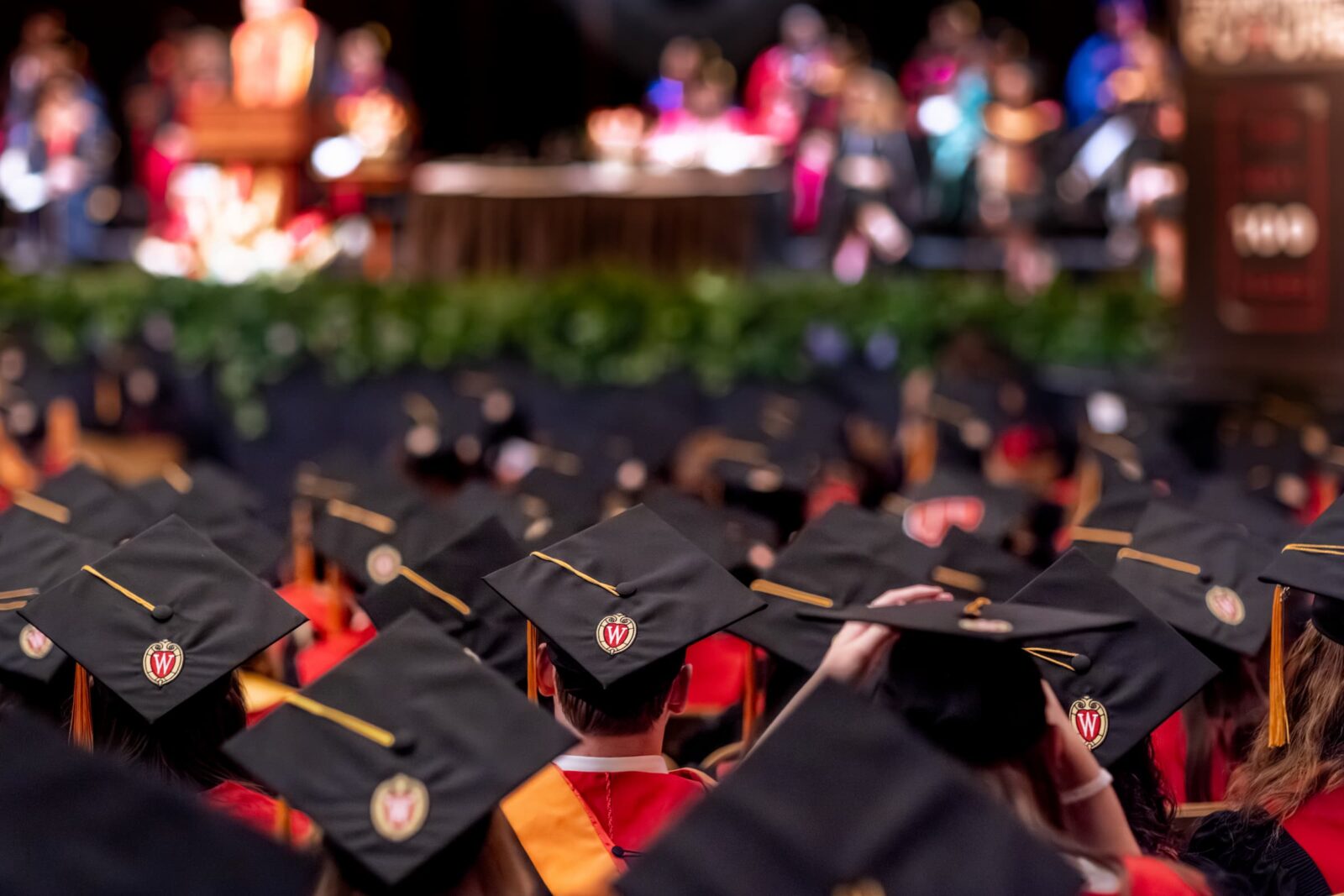 A sea of graduation caps as BSN students face the stage during graduation.